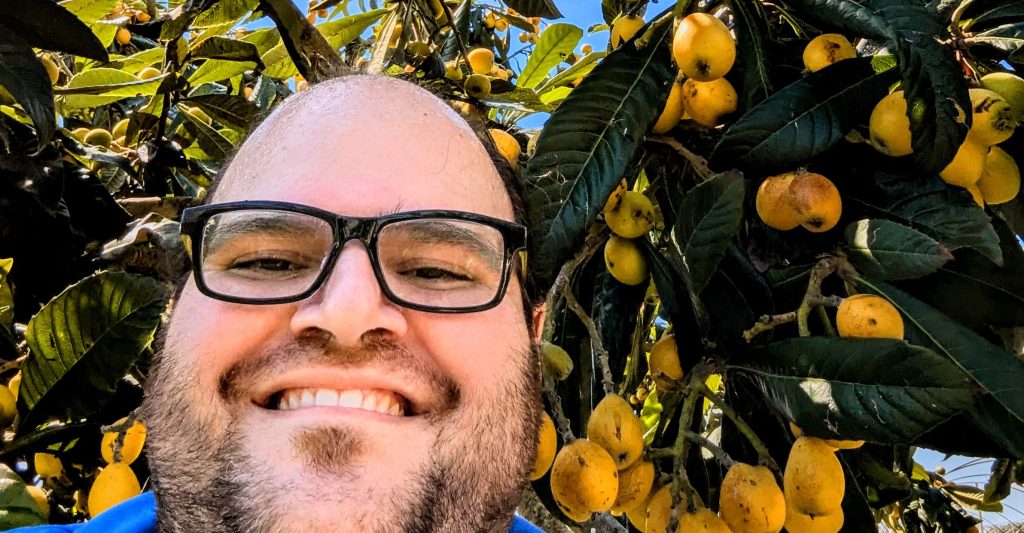 Luigi in front of a loquat tree, full of ripe fruit, at his Aunt's house in Central Italy.